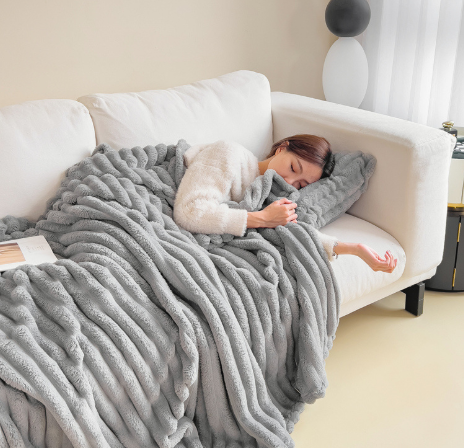 New silver gray ribbed plush blanket draped over a bed