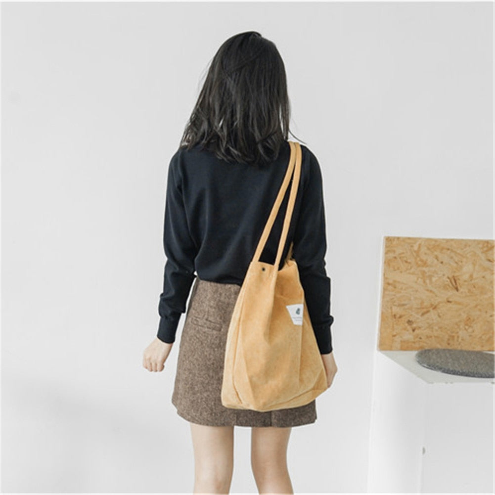 Tan canvas tote worn with a casual black outfit