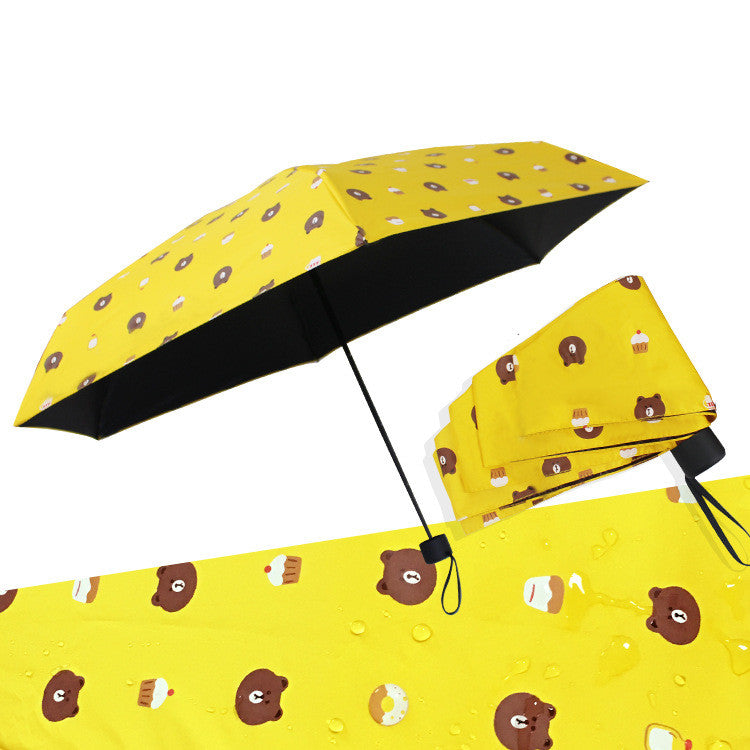 Yellow bear print travel umbrella open beside its capsule case