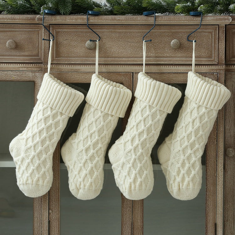 Cable Knit Christmas Stocking — four cream stockings hanging from hooks on a wood dresser