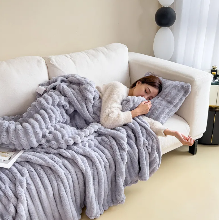 Silver gray ribbed plush blanket styled on a white couch