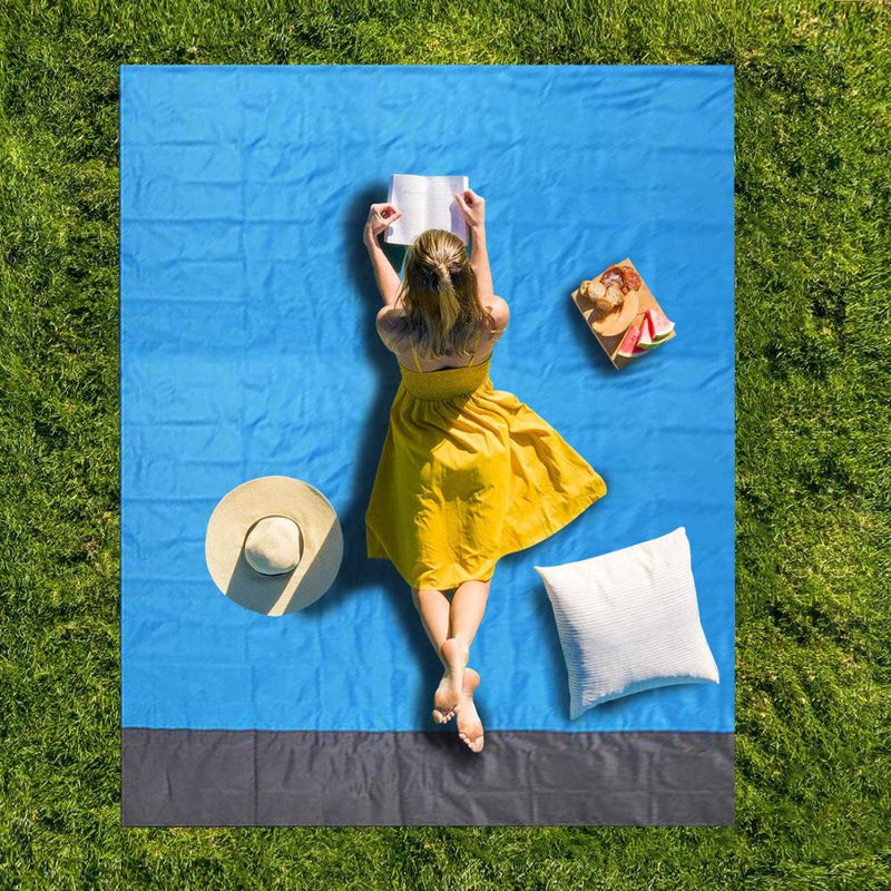 Relaxing on a blue pocket picnic blanket spread on the grass
