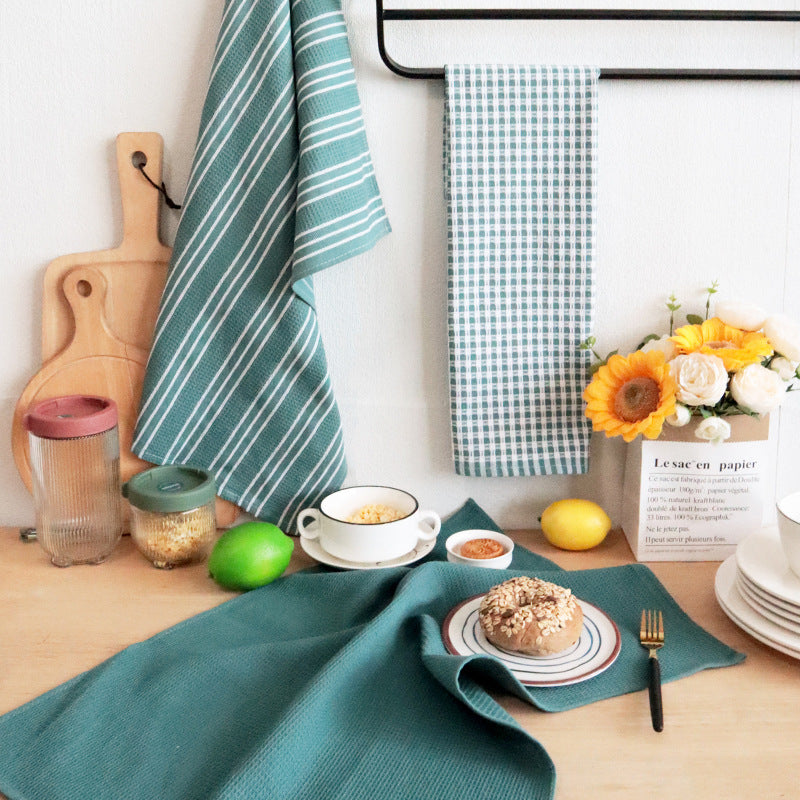 Green tea towels styled on a breakfast table