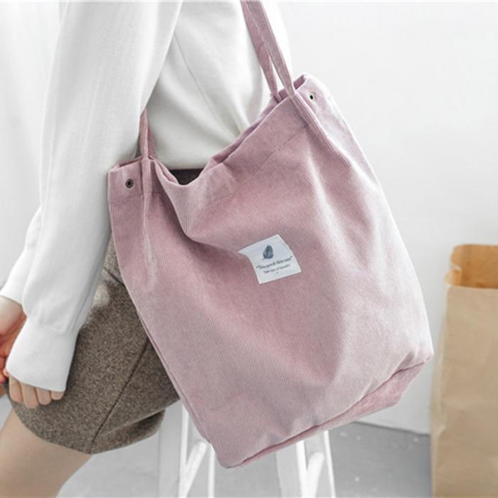 Woman carrying the pink corduroy everyday tote over her shoulder
