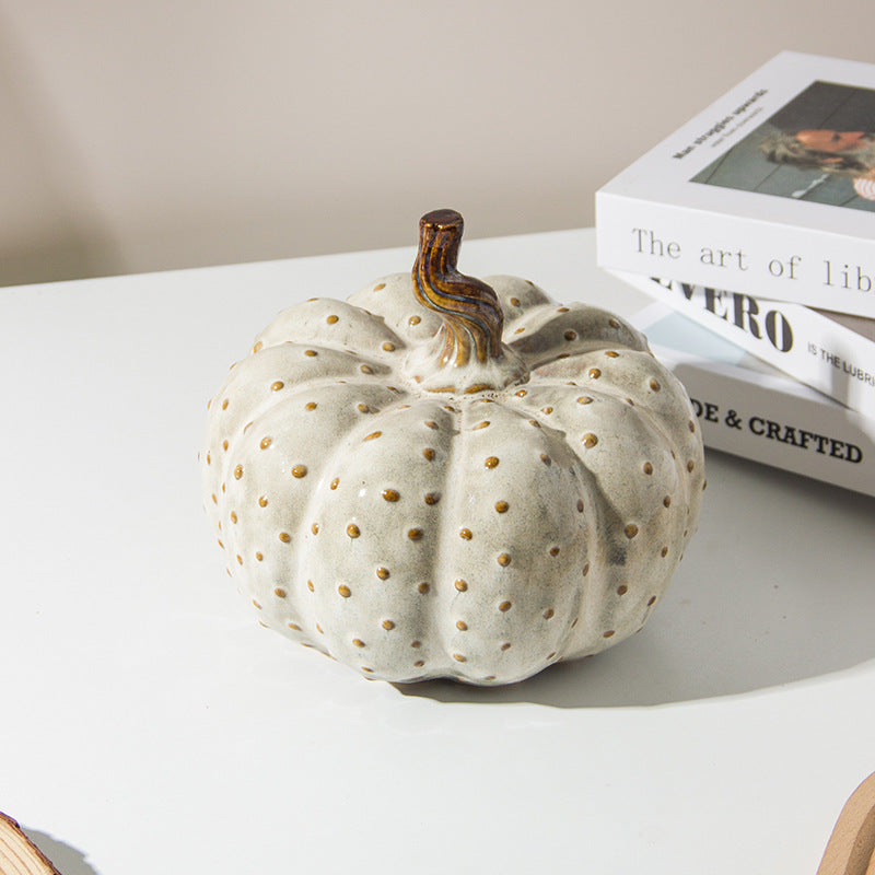 White Ceramic Pumpkin — on a side table beside books