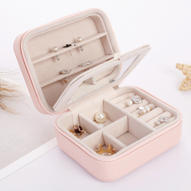 Pink travel jewelry case open showing ring rolls and compartments