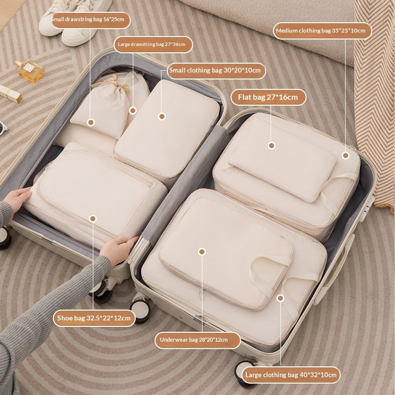 Beige eight piece packing cube set organizing clothes in a suitcase