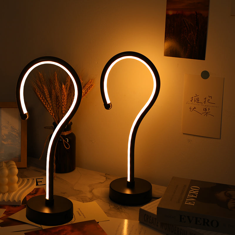 Pair of curve LED table lamps glowing warm on a desk