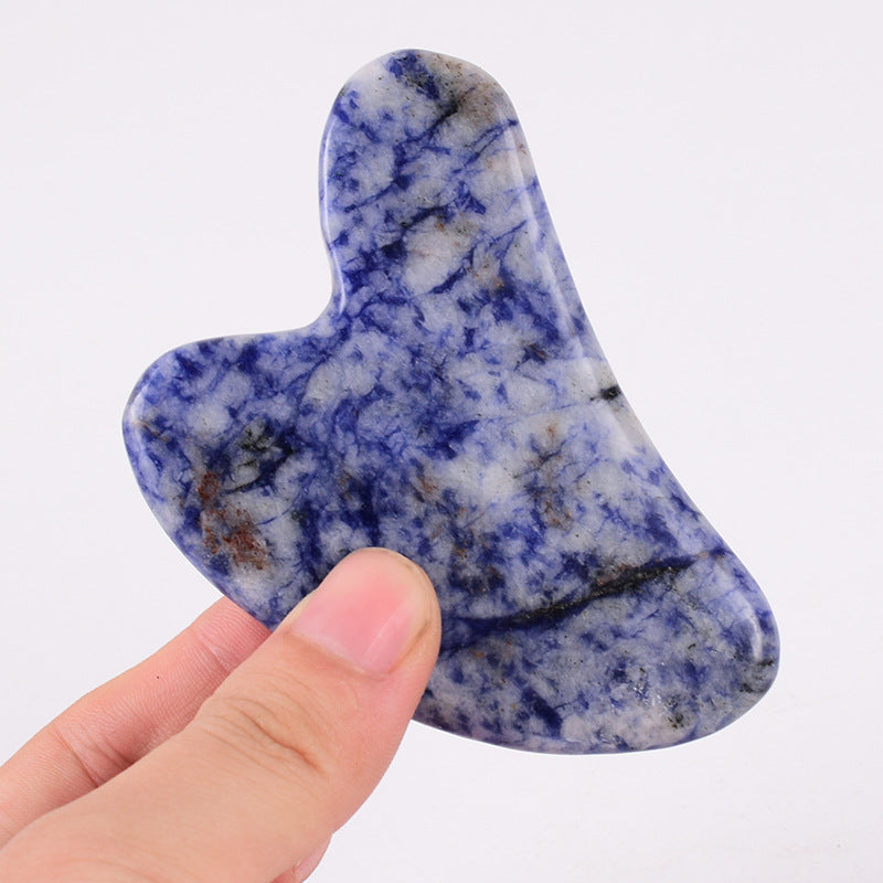 Heart shaped gua sha stone held to show its smooth polished edges
