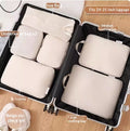 Beige six piece packing cube set arranged inside an open suitcase