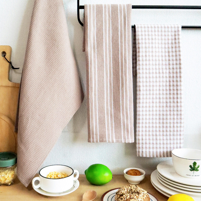 Coffee colored tea towels draped by a kitchen table setting