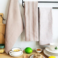 Coffee colored tea towels draped by a kitchen table setting