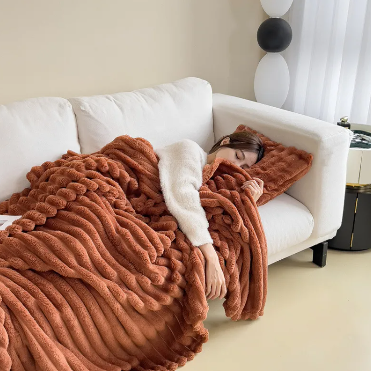 Caramel ribbed plush blanket spread across a white sofa