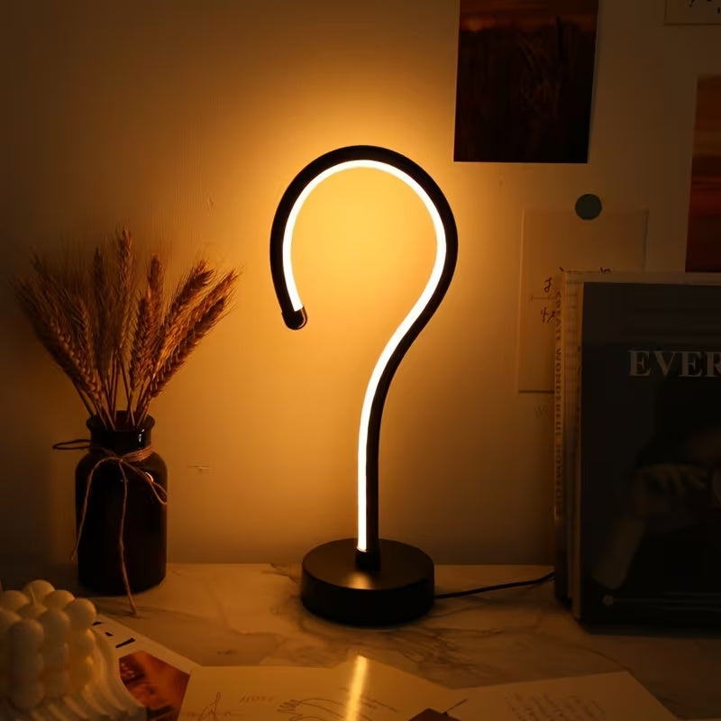 Curve LED lamp in warm amber light on a nightstand