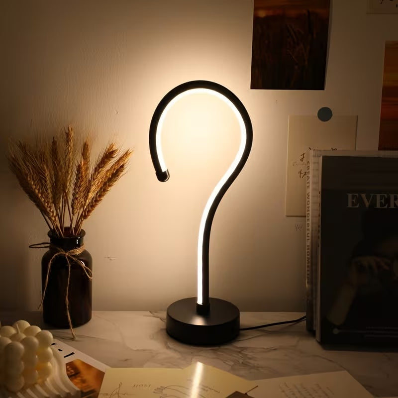 Single curve LED lamp lit warm in a dark room