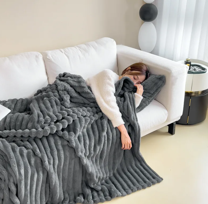 Dark gray ribbed plush blanket on a living room sofa