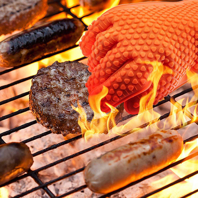 Silicone oven mitt gripping a burger over a flaming grill