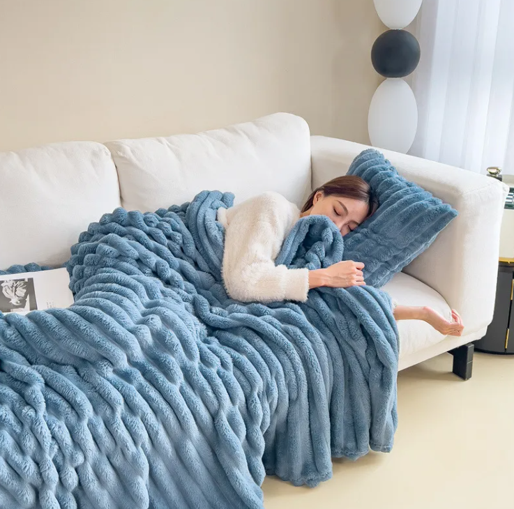 Blue ribbed plush blanket covering a sofa for an afternoon nap