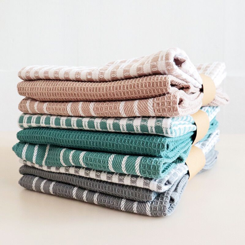 Stack of folded tea towels in assorted colors and patterns