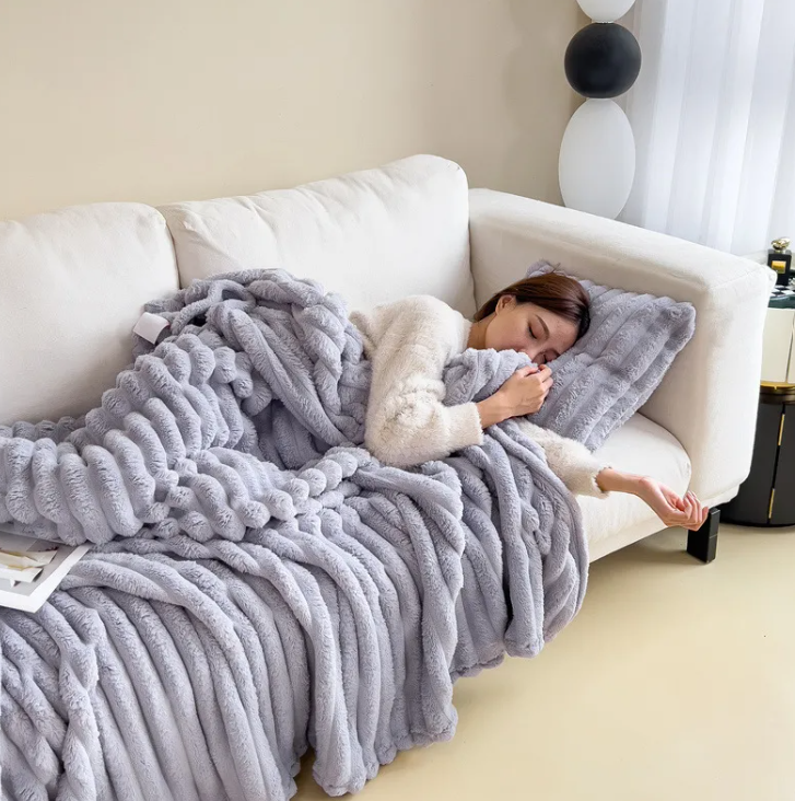 Purple ribbed plush blanket draped around a woman's shoulders
