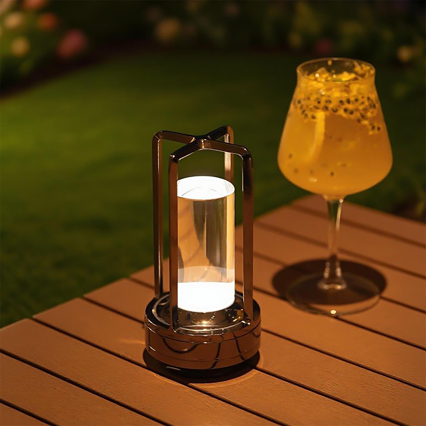 Cordless accent lamp on an outdoor table at golden hour beside a cocktail