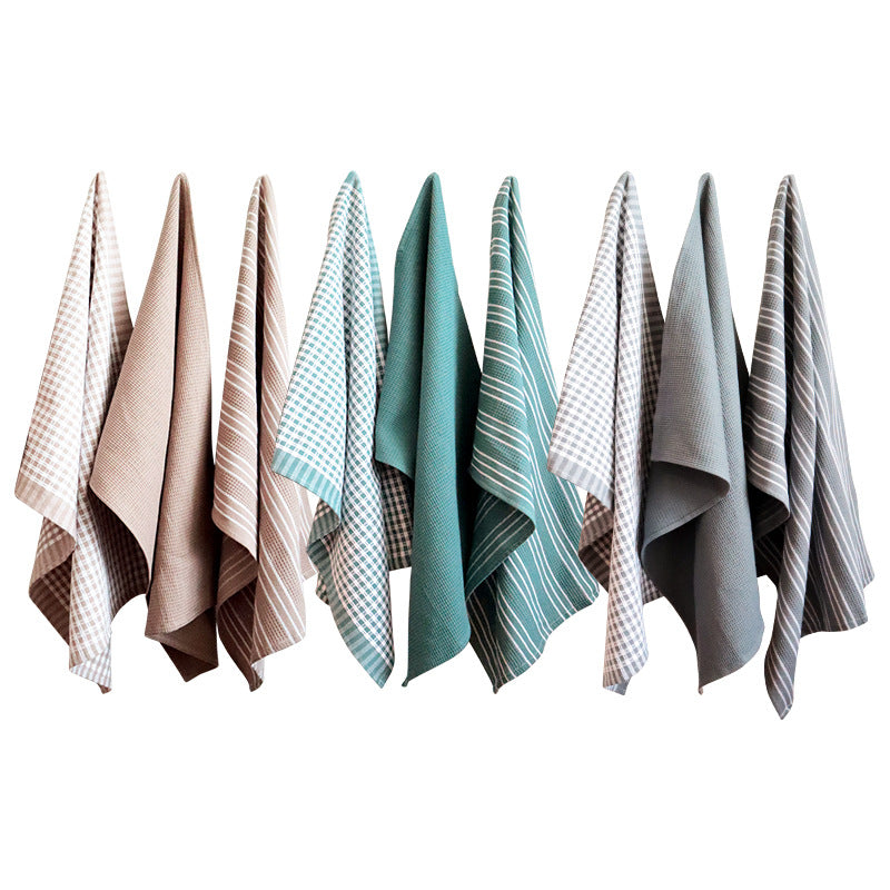 Assorted cotton tea towels hanging in a row