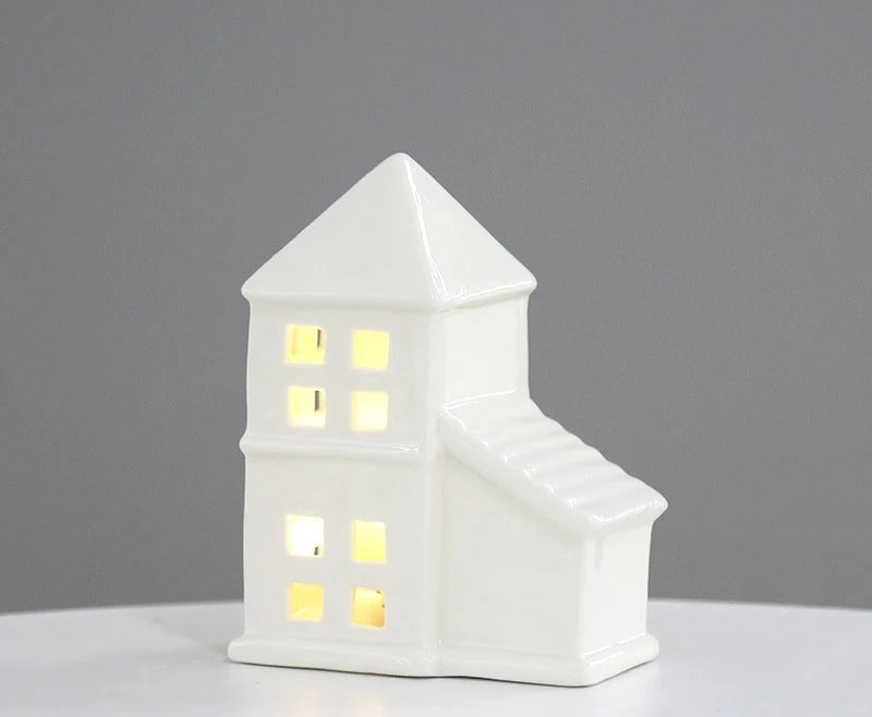 White ceramic chapel tea light house with tower, lit warmly