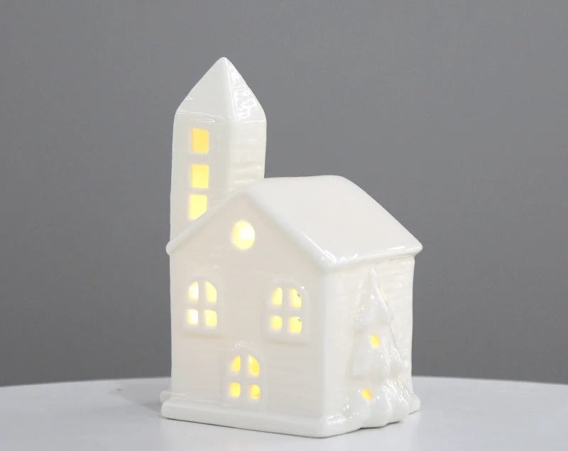 White ceramic church tea light house with steeple, glowing windows