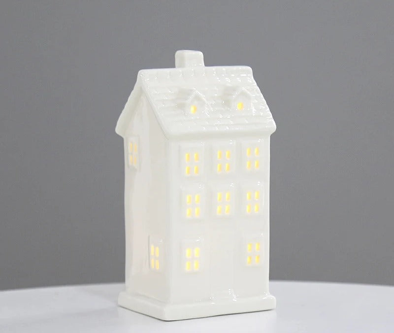 White ceramic manor house tea light holder with rows of glowing windows