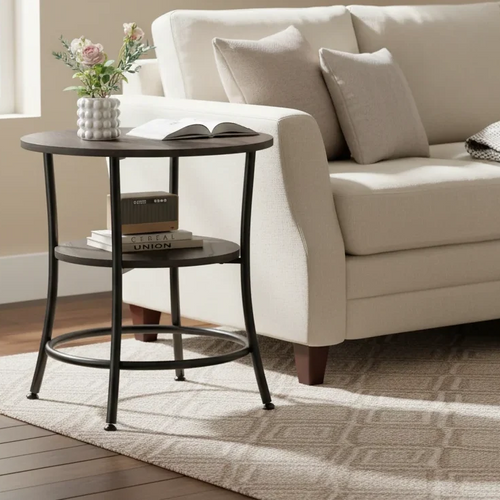 2-tier round side table styled with flowers and a book beside a cream sofa in a bright living room